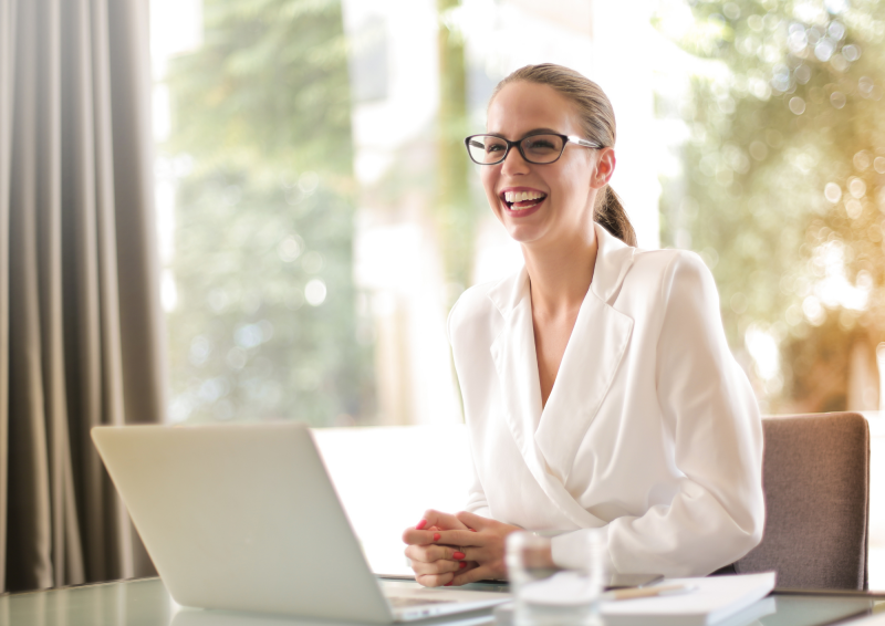 Professional woman with laptop laughing and smiling off in the distance