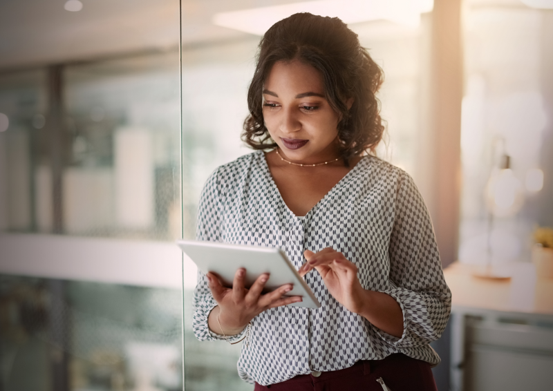 Businesswoman looking down at a tablet she's holding