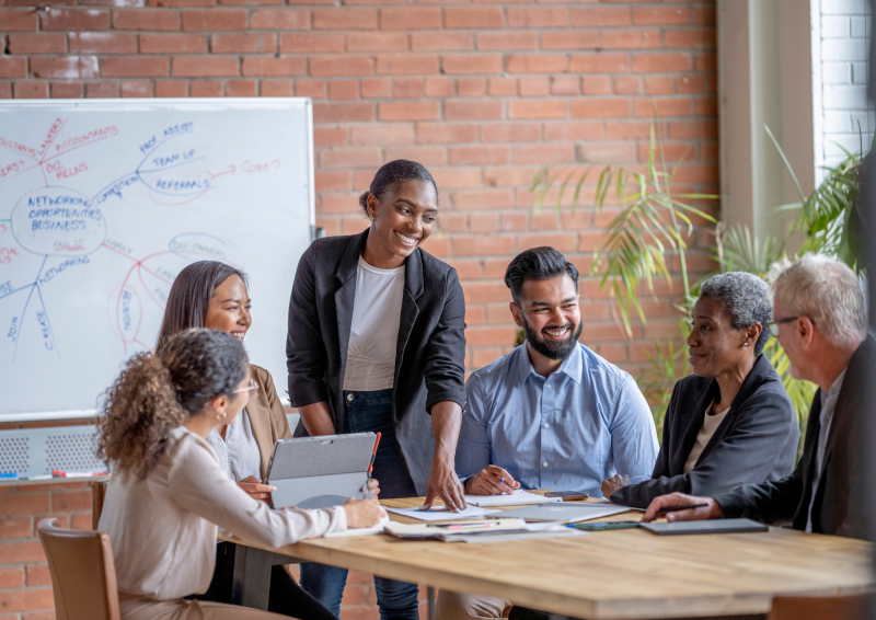 a team of workers gathered around a table brainstorming ideas