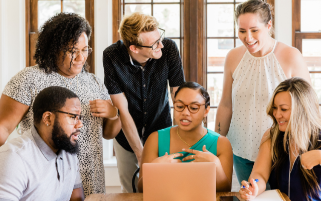 group of admins gathered around laptop