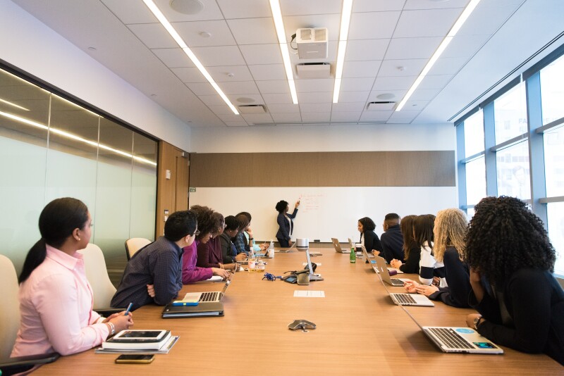 Executive assistant onboarding new employees seated around table