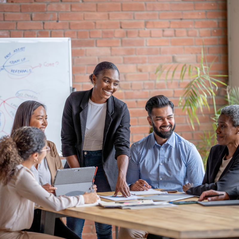 a team of workers gathered around a table brainstorming ideas