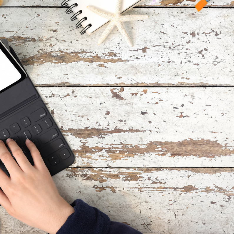 executive assistant typing on a small laptop