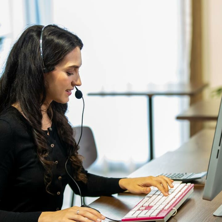 An executive assistant sitting at her desk while using the count function in Excel.