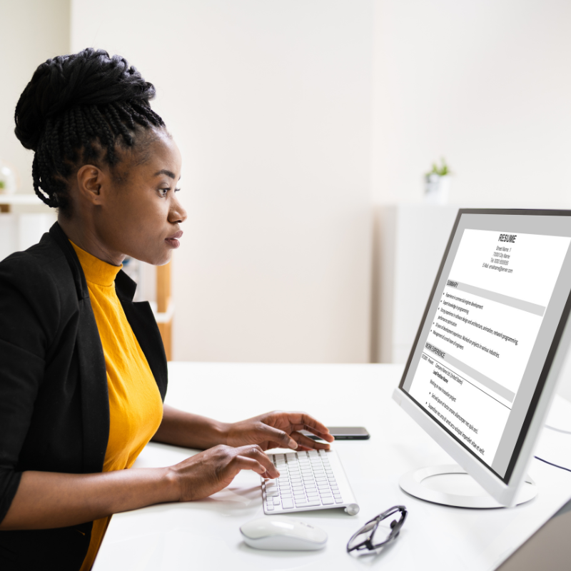 Woman updating her resume on her desktop.