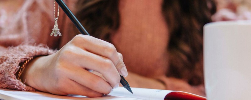 An administrative or executive assistant practicing their speedwriting skills in a close up of their hand and pen.