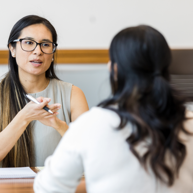Two women talking at desk