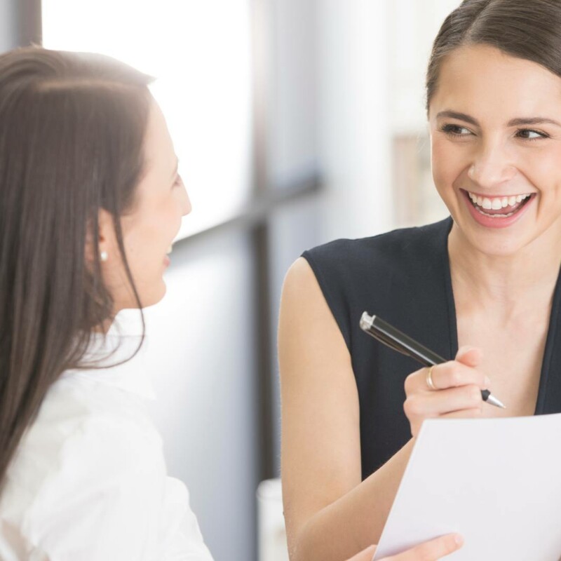 An executive assistant and her boss talk to each other, demonstrating adaptability.