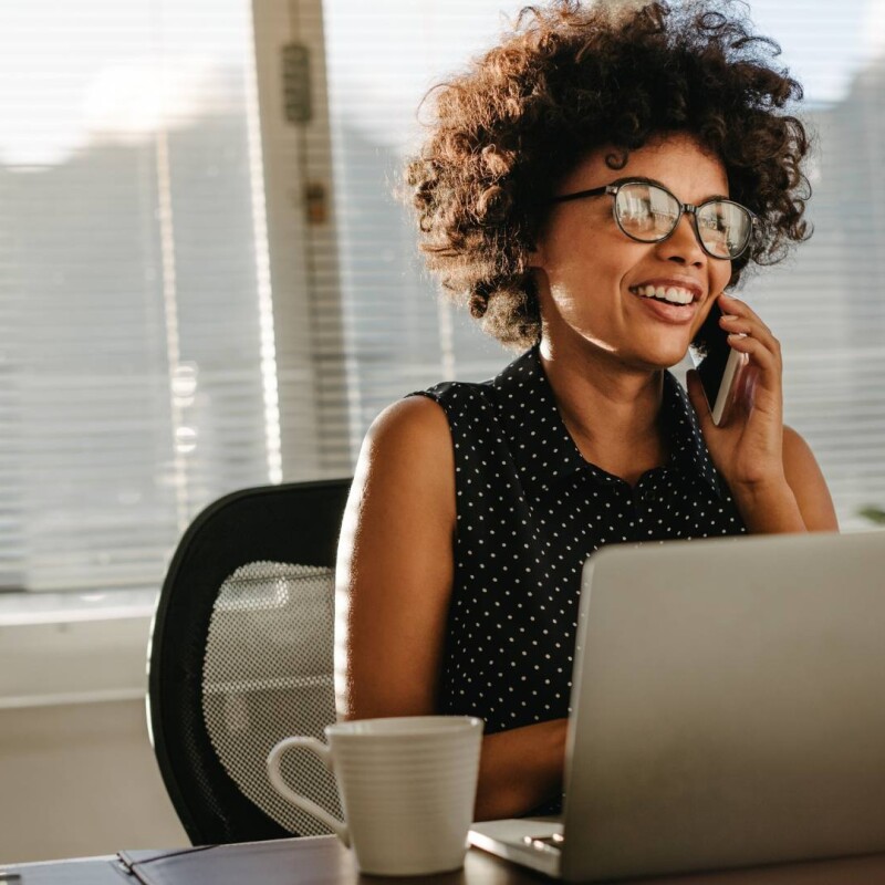 A woman sits at a desk on her laptop, utilizing admin tools to streamline her workflow.