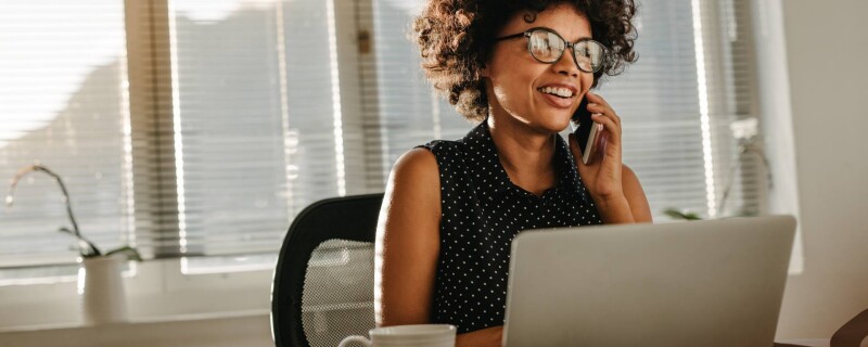 A woman sits at a desk on her laptop, utilizing admin tools to streamline her workflow.