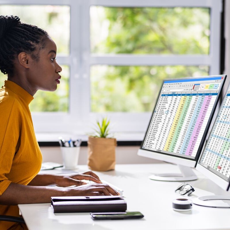 Administrative professional organizing and analyzing spreadsheets.