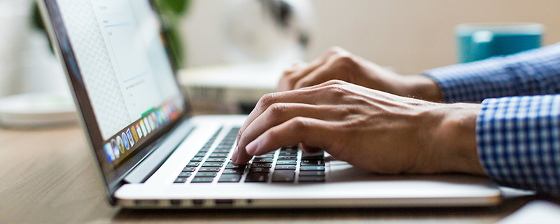 man typing on laptop keyboard