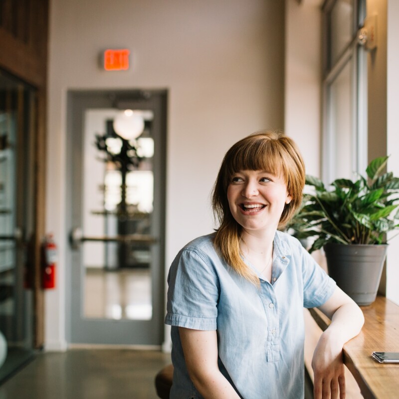 woman wearing blue shirt and smiling