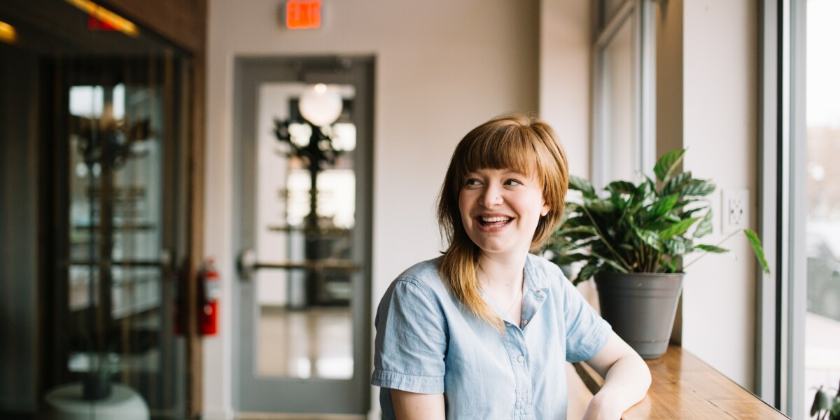 woman wearing blue shirt and smiling