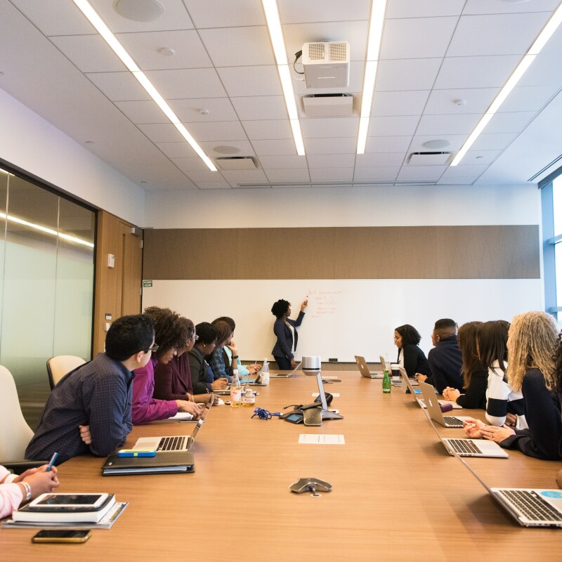 Executive assistant onboarding new employees seated around table