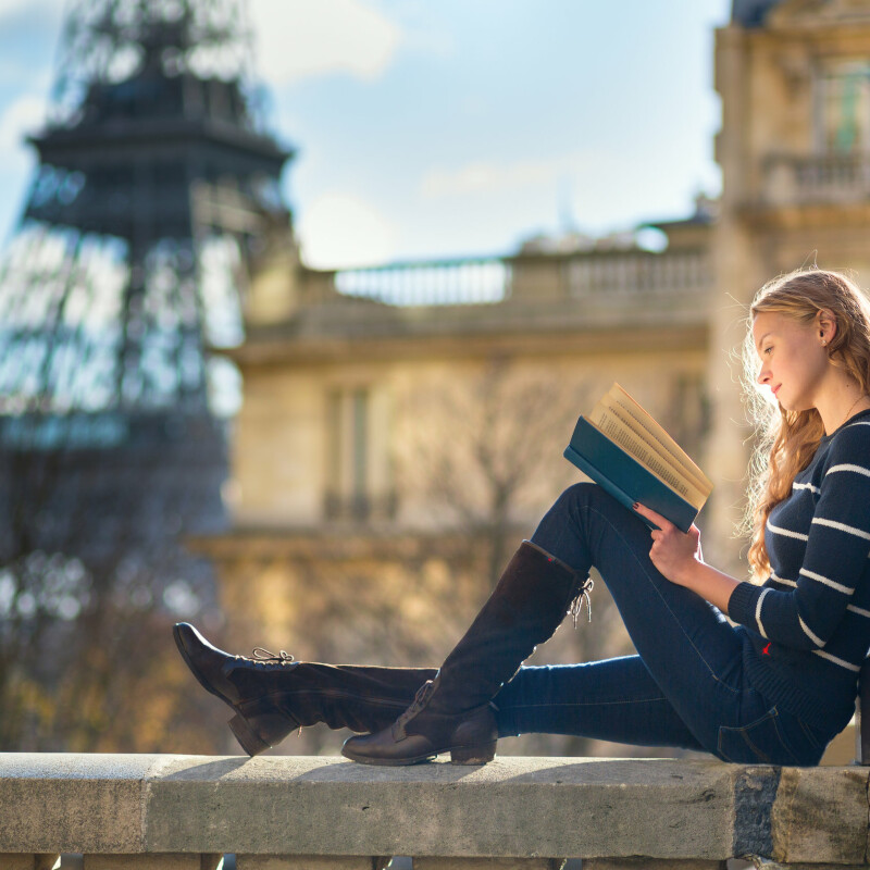 woman continuously learning by reading a book to stay informed on topics around the world