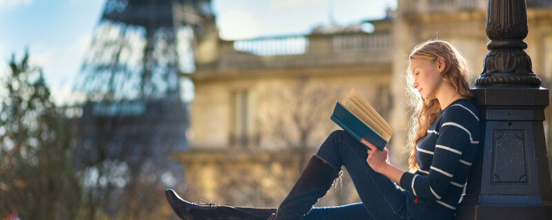 woman continuously learning by reading a book to stay informed on topics around the world