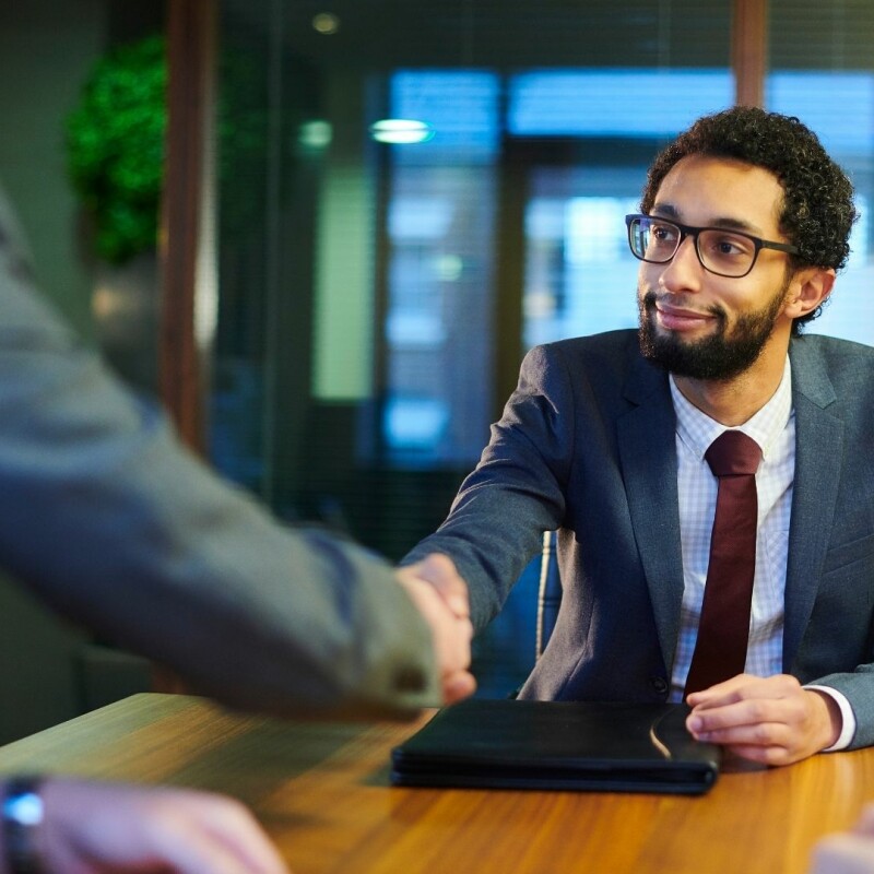 gentlemen gets a handshake in approval of his dream job interview