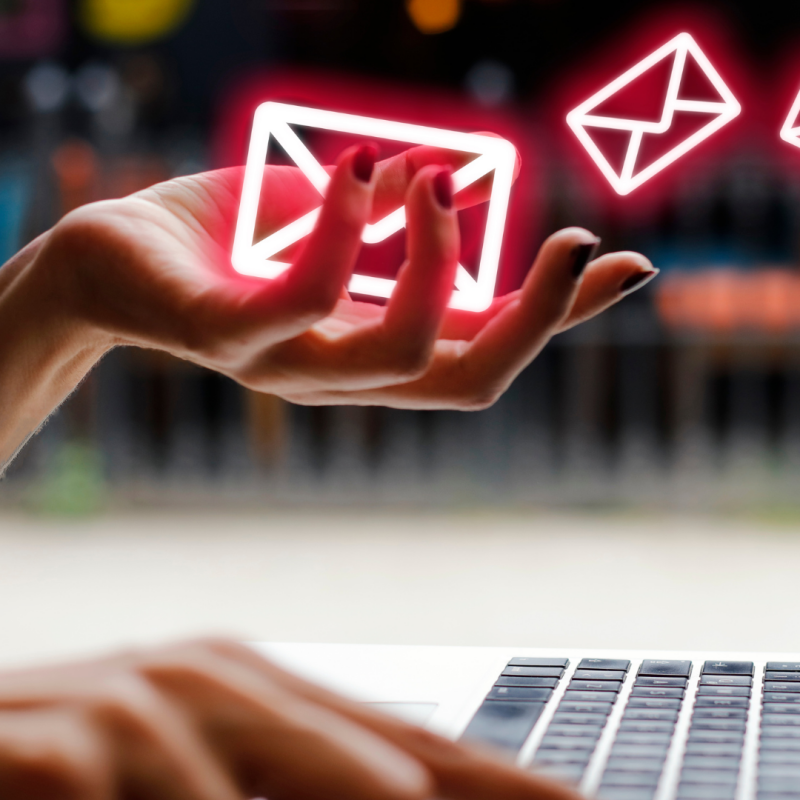 hand holding neon email icons