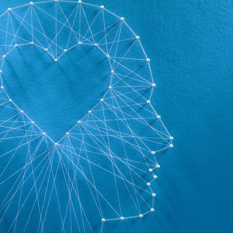 Many different threads connect from the shape of a head to a heart in the center.
