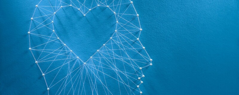 Many different threads connect from the shape of a head to a heart in the center.