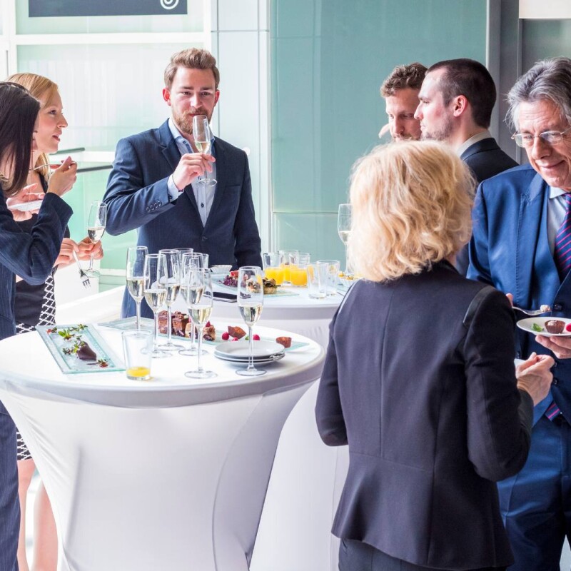 A group of professionals gather around a table at an event, demonstrating successful event management.