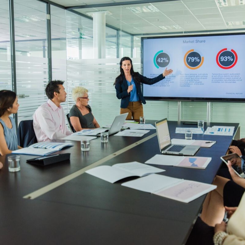 Executive delivering a presentation, using visual aids and engaging design to enhance audience understanding.