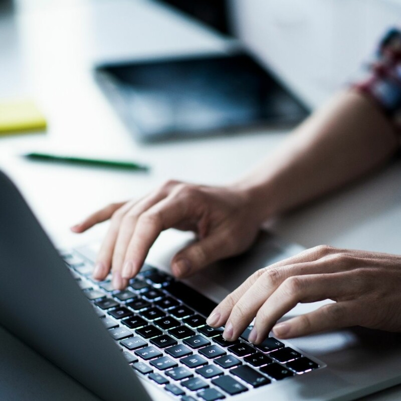 person typing fast on laptop