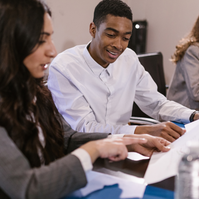 coworkers sitting at a table and reviewing documents together