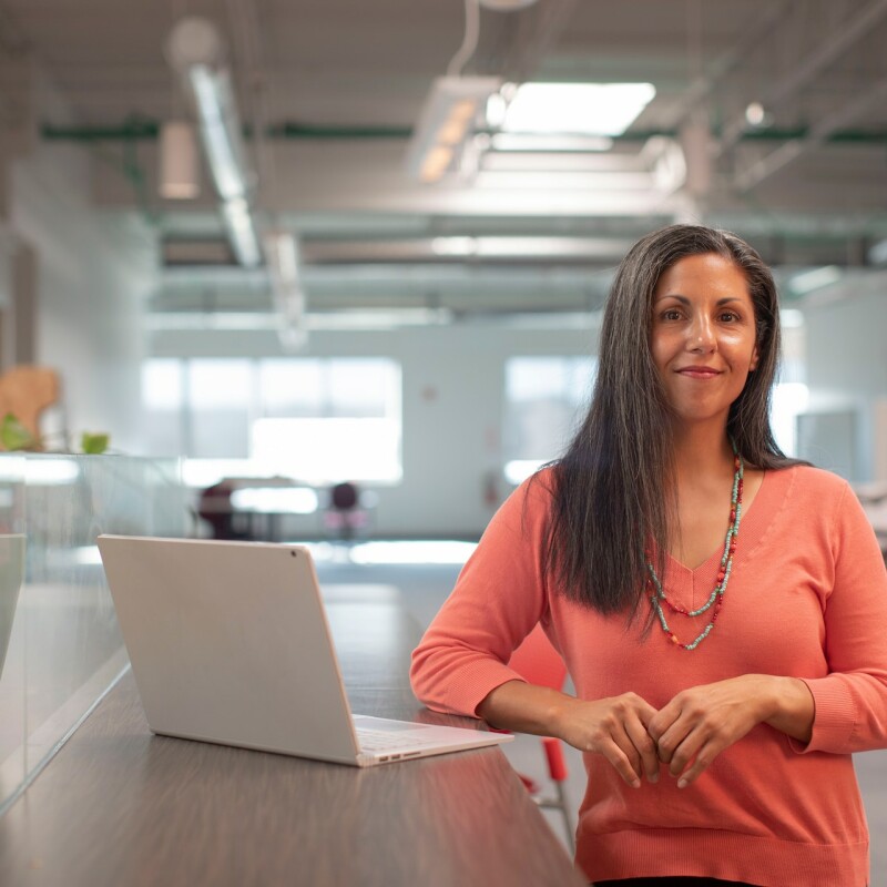 woman standing in office with laptop