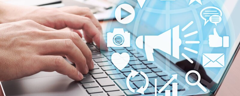 A person types on a laptop with a graphic of social media symbols, demonstrating social media management.