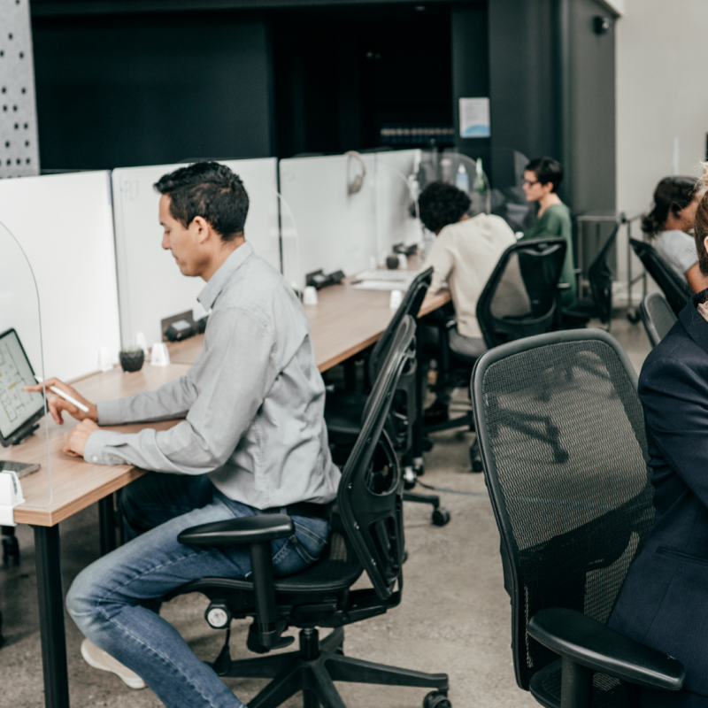 administrative employees working in an open office with cubicles