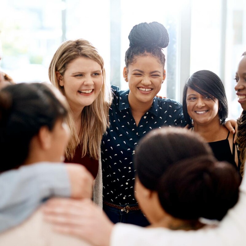 A group of employees stand together in a circle, demonstrating the power of positive thinking.
