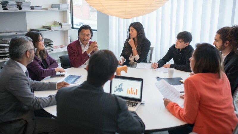 Coworkers around a table discussing organizational changes.