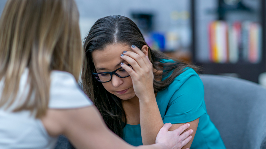 woman comforting another woman who is stressed at work