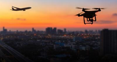 Silhouette of drone flying near an airport with airplane, no drone zone concept