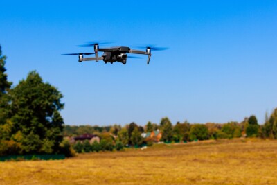 Close-up view of drone flying over agricultural field. Flying drone quadcopter over the harvest field