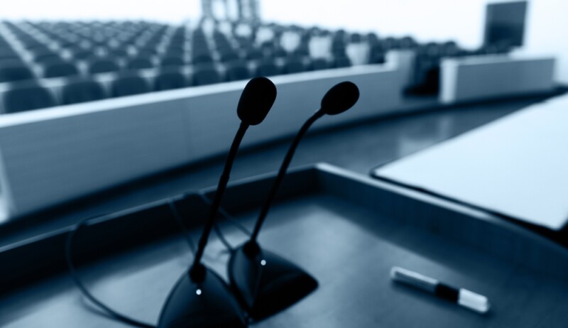 Before a conference, the microphones in front of empty chairs