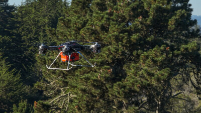 A Firefly drone flying in front of trees