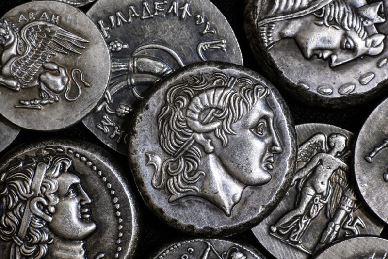 Ancient Greek coin with Alexander the Great portrait, pattern of silver tetradrachms. Top view of old vintage metal money with man face. Concept of Greece, texture, collection, art and history.