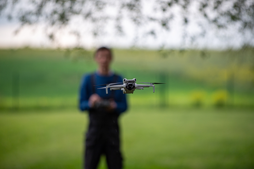 Drone in flight with pilot in the summer background