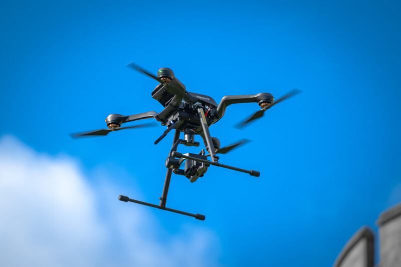StirlingX branded drone flying in blue sky with clouds