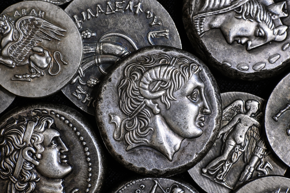 Ancient Greek coin with Alexander the Great portrait, pattern of silver tetradrachms. Top view of old vintage metal money with man face. Concept of Greece, texture, collection, art and history.