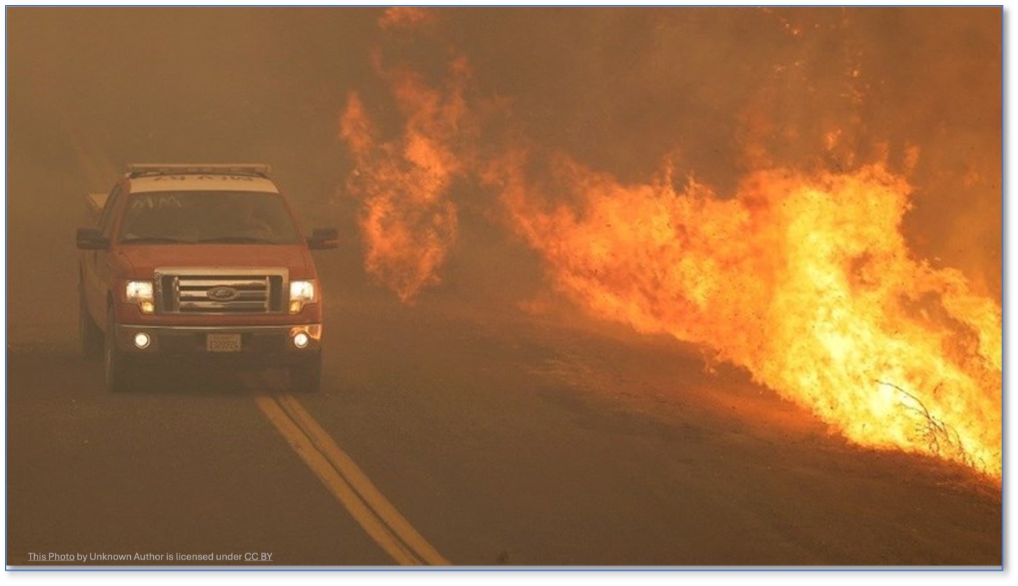 Fire truck driving next to wildfire