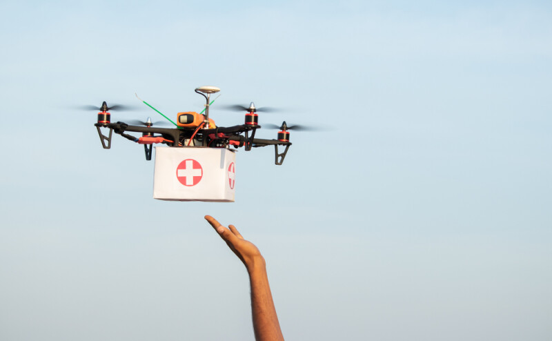 hand releasing drone with medical package attached to it