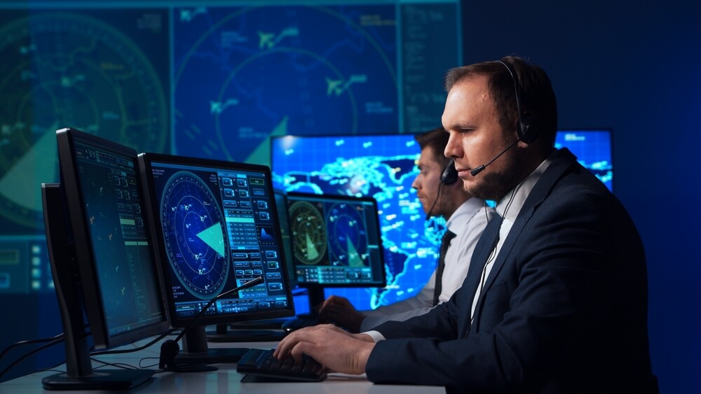 Team of professional aircraft control officers works using radar, computer navigation and digital maps.