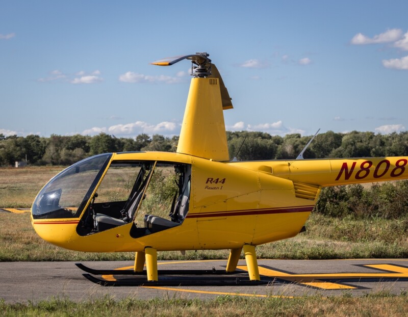 NORWOOD, US - Aug 31, 2022: Robinson R44 helicopter parked at airport for scenic tours with doors removed.