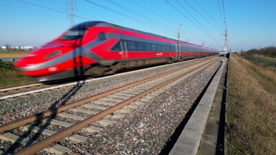 red train moving fast on tracks