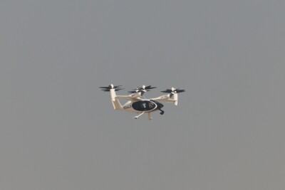  Electric vertical takeoff and landing air taxi captured in stable flight against a clean sky during the Dubai Airshow, representing the future of urban air mobility, sustainable aviation, and next generation transport technology