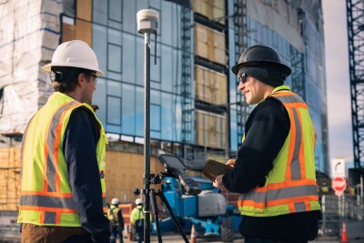 Two workers standing next to the R980 GNSS System